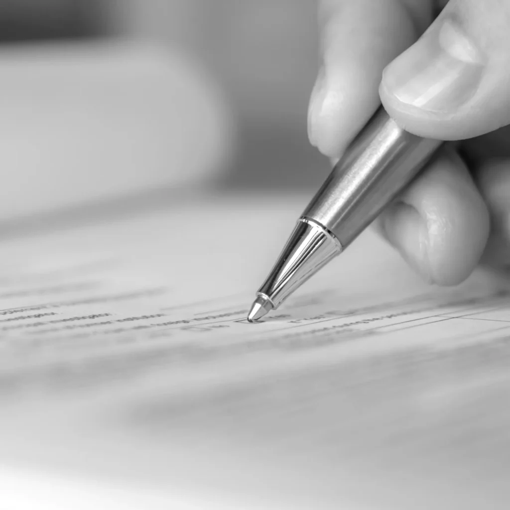 Steuerliche Aspekte der Vermögensnachfolge - Bild: Hand mit silbernem Kugelschreiber auf Papier (Closeup), Notar Hebebrand